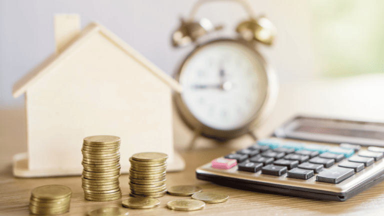 Coins, calculator and a clock on a table